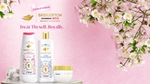 Pink floral background showcasing three Dove "Bridgerton Collection" shower products.