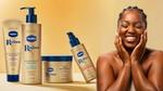 A campaign image for Vaseline Radiant X, featuring a Black woman laughing, and a range of four products in gold and blue packaging including body lotions and body oil.