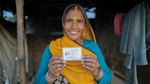 A woman smiling while holding an identity card