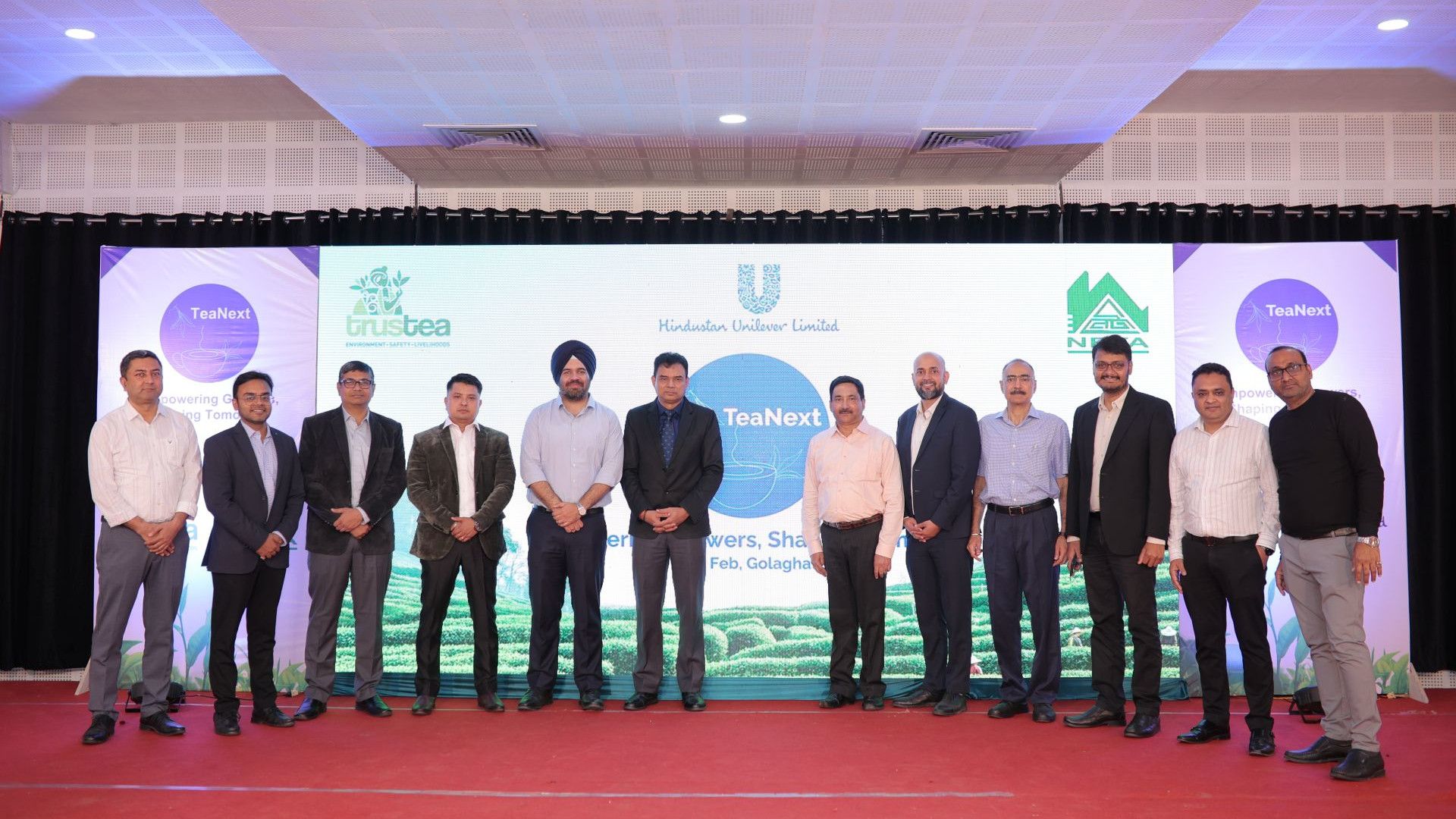 A group of people posing for a picture at an event for Tea Next.