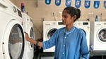 A Suvidha Centre worker using a washing machine at HUL Suvidha Centre