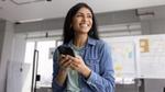 An indian woman smiling holding a phone