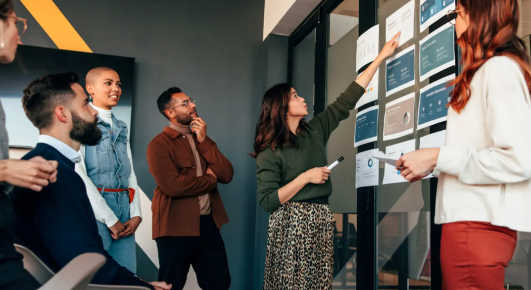 A group of people looking at papers on a board