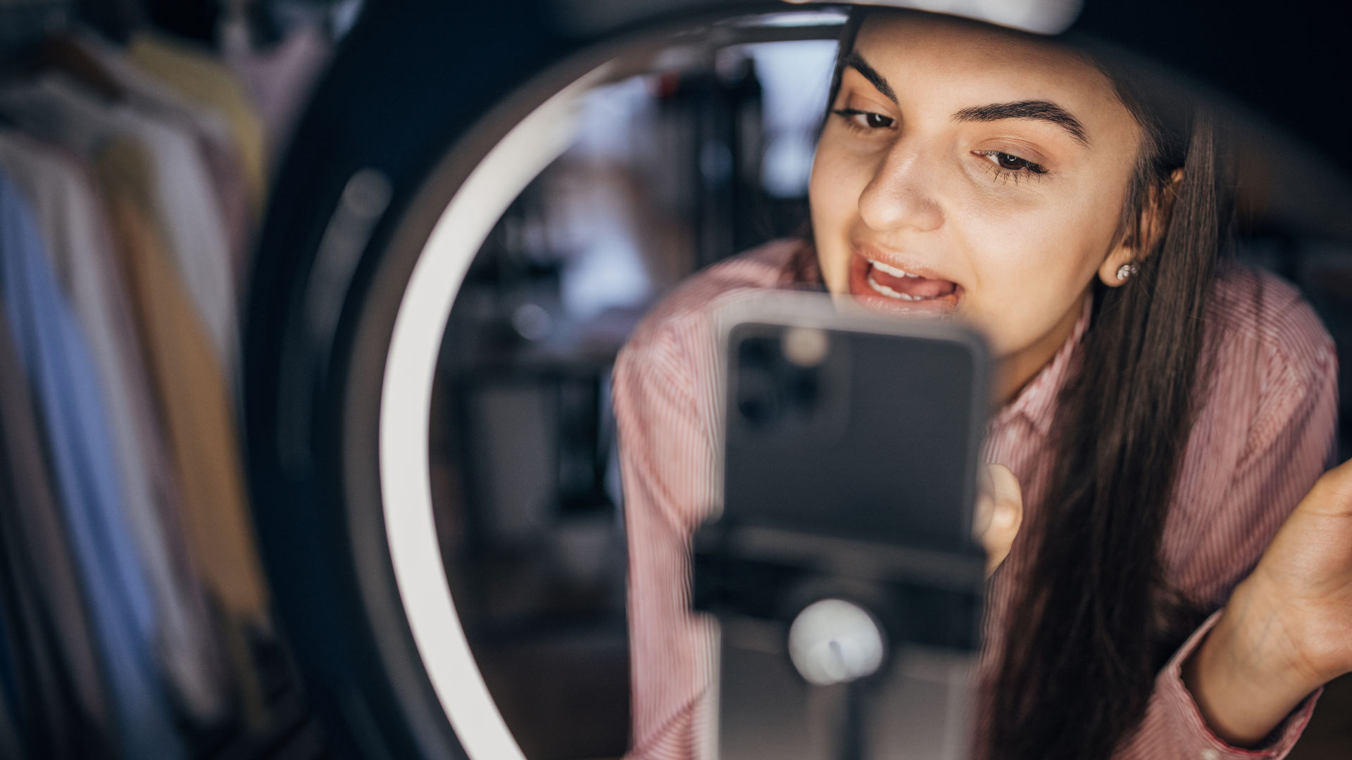 Woman filming herself with a smartphone and ring light