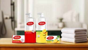 Lifebuoy body wash and soap bars with folded towels on a wooden surface