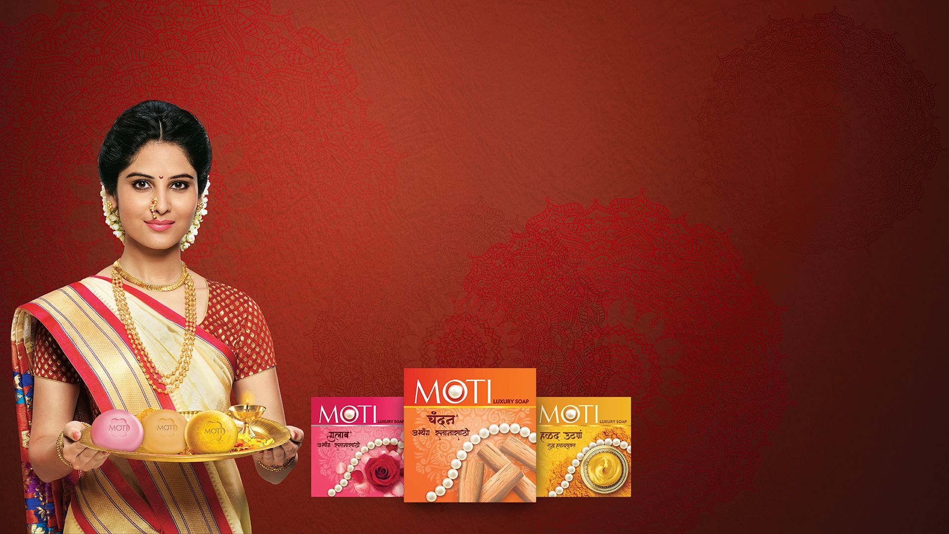 An indian woman holing a plate with Moti products beside her