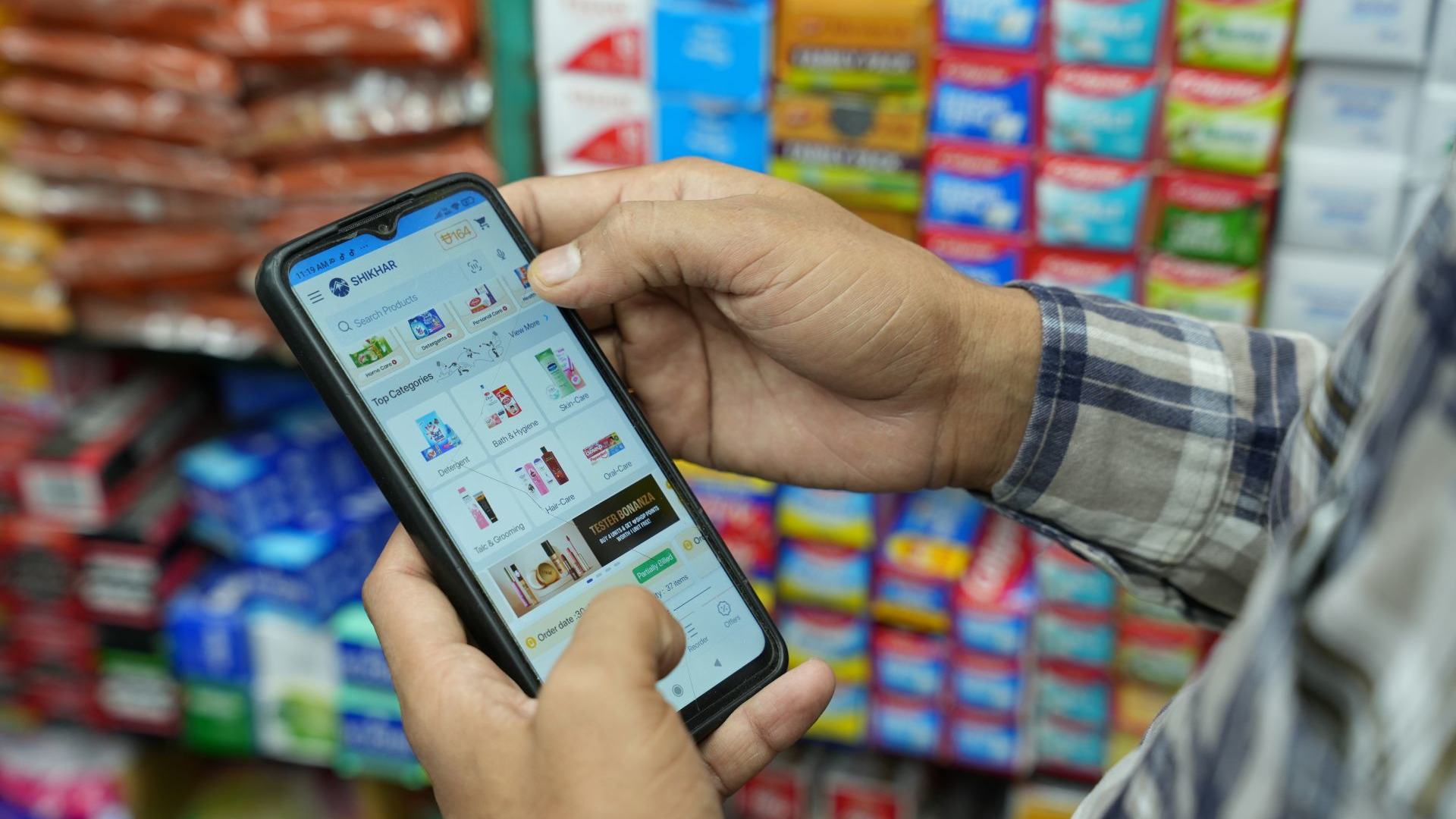 A man uses his smartphone to look up products in a retail environment.