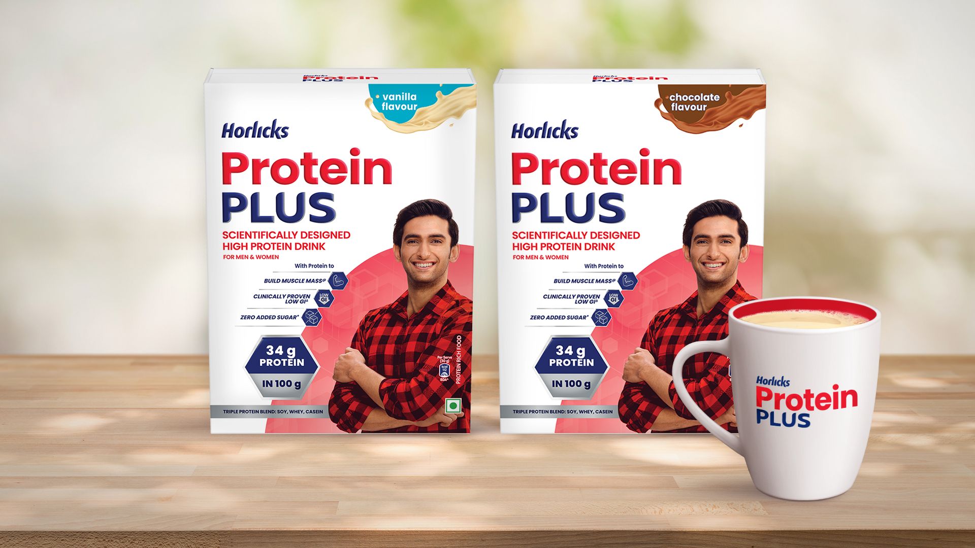 Two packs of Horlicks Protein Plus packs in vanilla and chocolate flavours featuring a man in a red shirt, along with a filled mug displayed on a wooden surface.