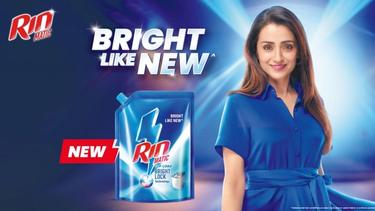 Rin Matic ad showing a woman in a bright blue dress and a detergent pack with the tagline "Bright Like New."