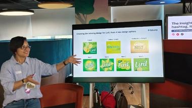Person presenting Liril soap packaging design options on screen.