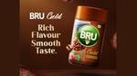 An advertising for a packet of Bru Gold Premium Instant Coffee with a background of coffee beans
