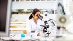 A woman in a laboratory using a microscope