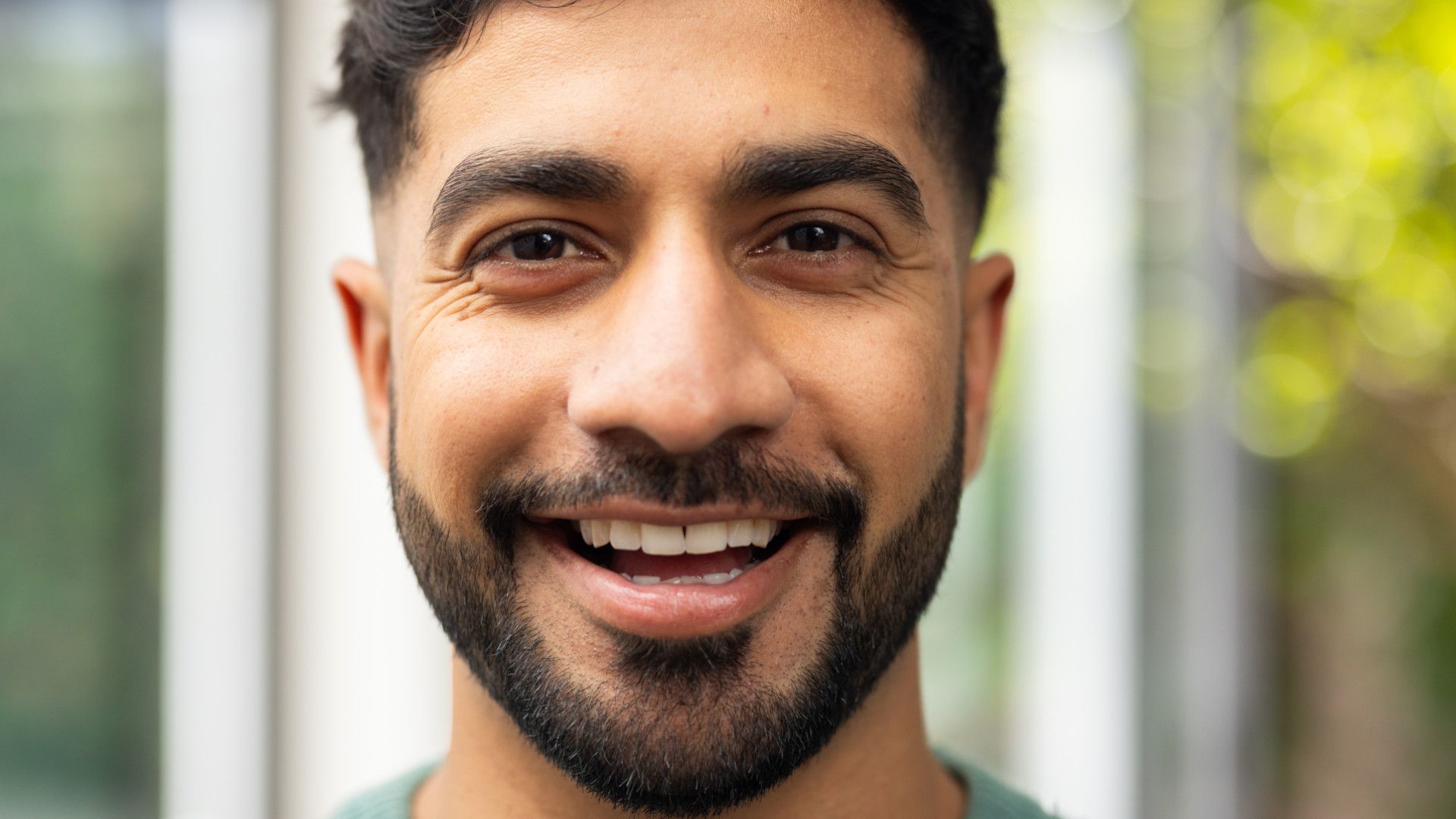 A bearded man looking at camera