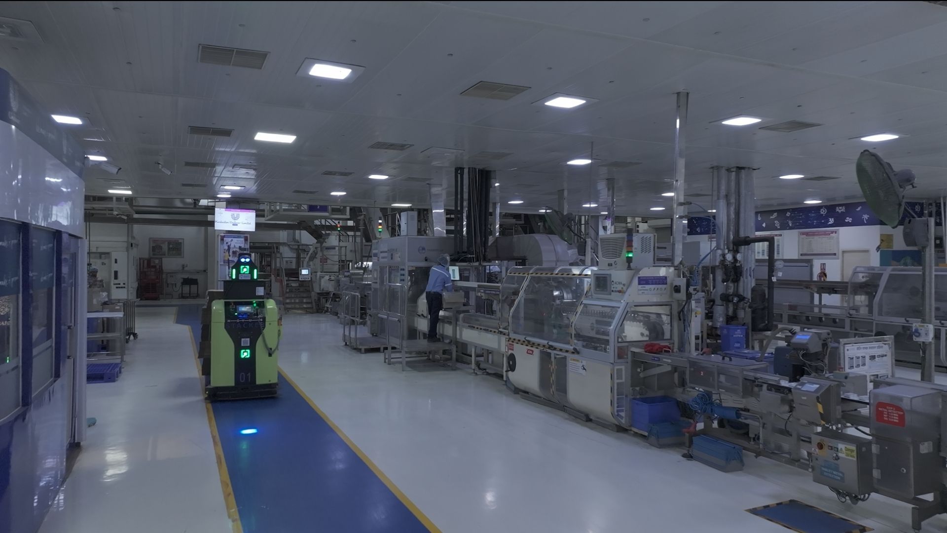 Automated factory with machinery and robotic vehicle in operation.