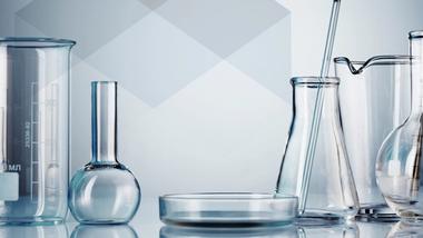 close up of a lady looking through a microscope at a sample in a petri dish