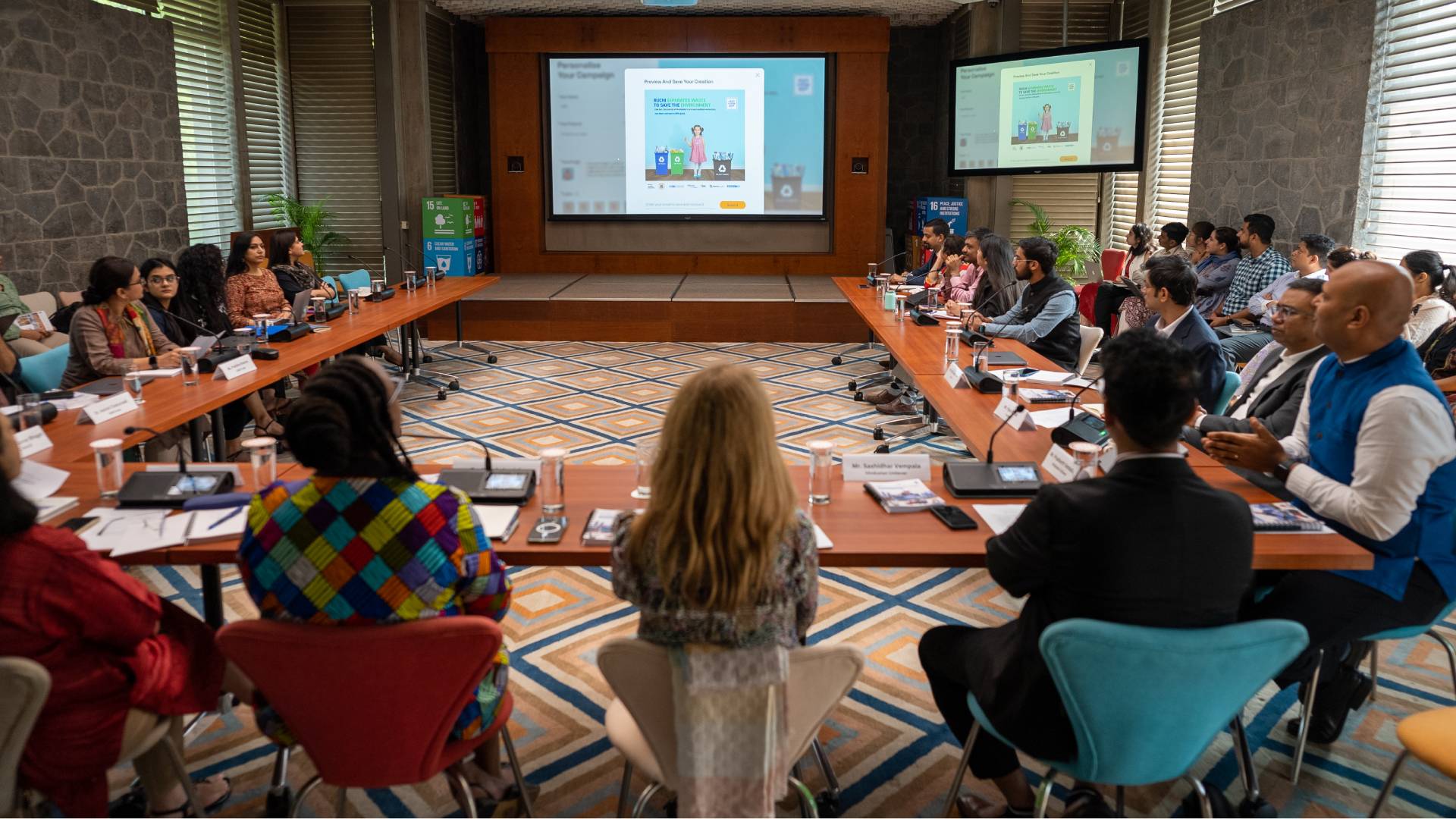 People attending a meeting in a conference room with a presentation on screen.