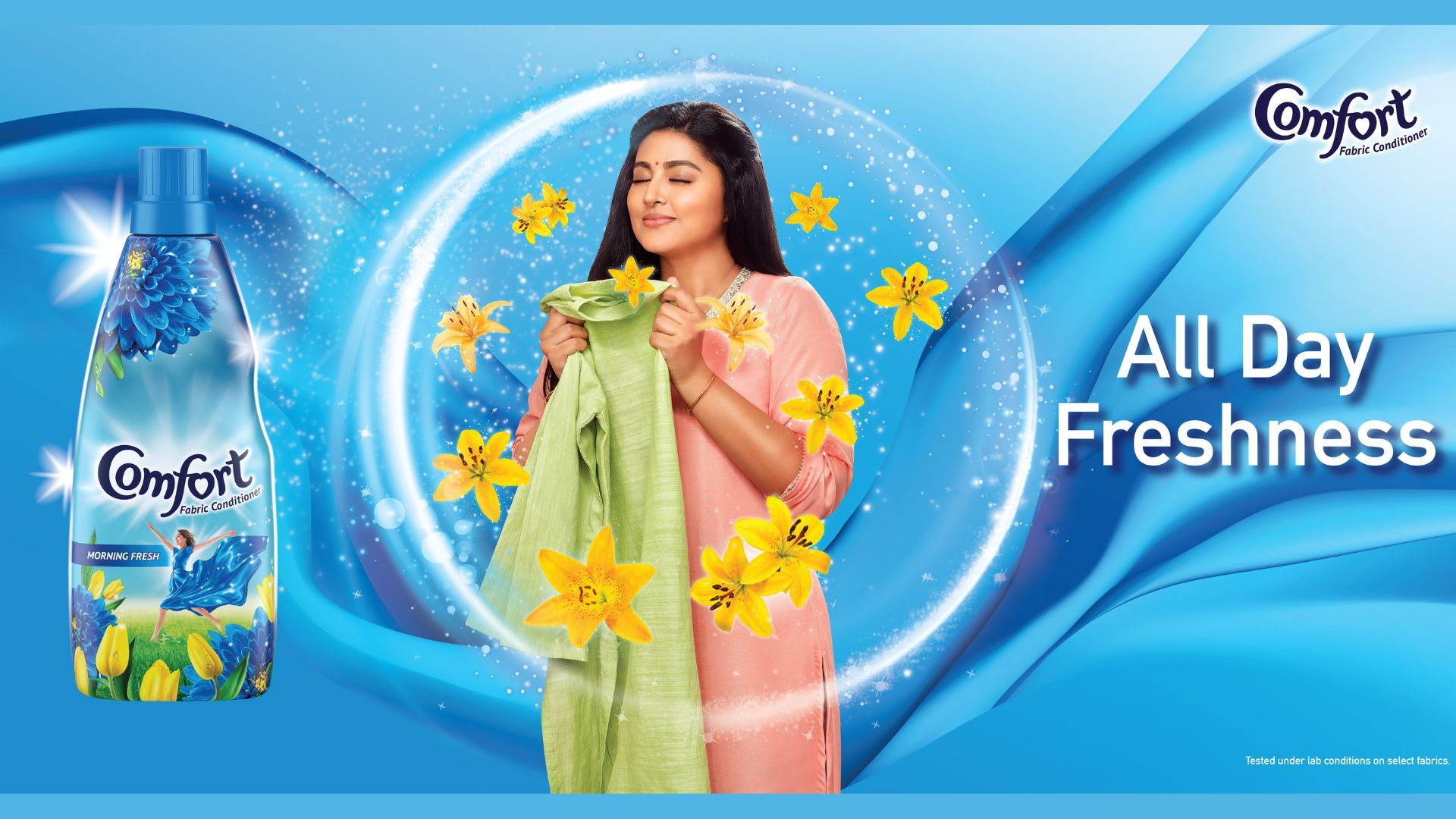 Image of a woman smelling her clothes after being washed with Comfort - All day freshness.