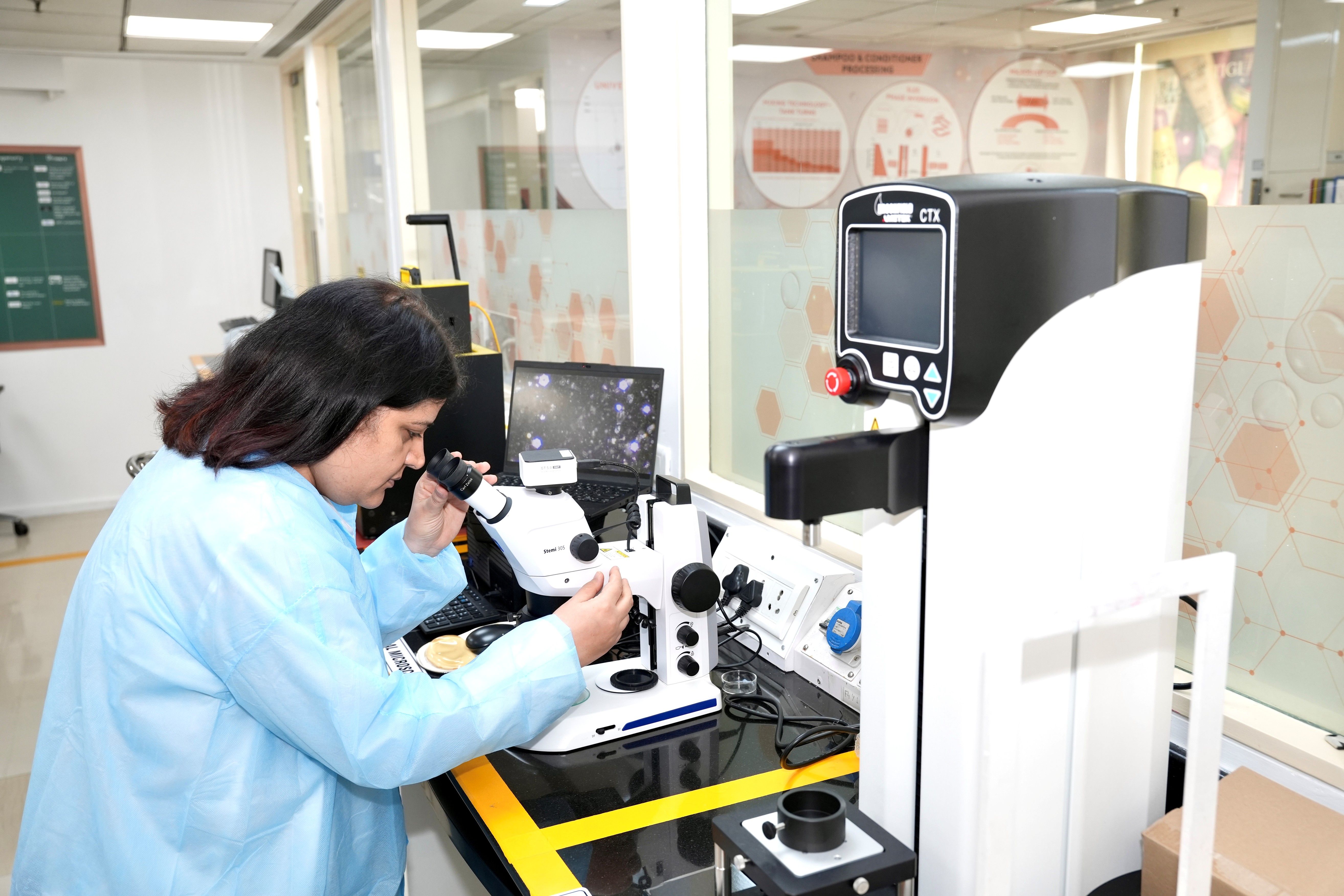 A scientist looking through a microscope