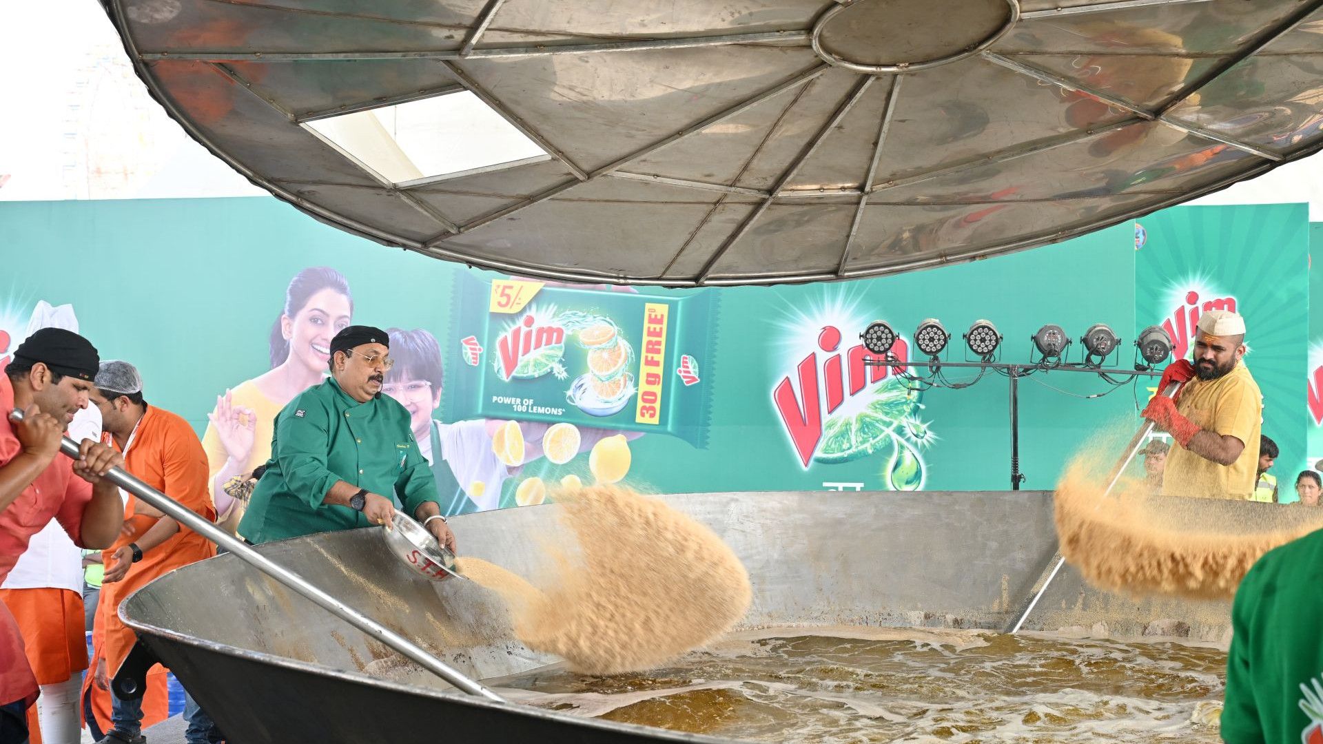Three men putting ingredients to make halwa.